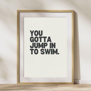 Peut inclure: Une impression encadrée avec un fond blanc et un texte noir qui dit "YOU GOTTA JUMP IN TO SWIM."