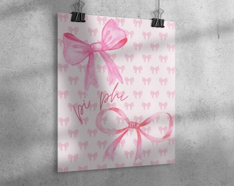 May include: A pink watercolor print featuring two large bows and a repeating pattern of smaller bows. The words "pi phi" are written in cursive. The print is held by two black binder clips, hanging against a gray concrete wall.