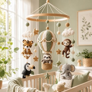 May include: A nursery mobile featuring a central crocheted hot air balloon with a sloth in the basket, surrounded by crocheted figures of a tiger, monkey, toucan, and elephant, accented with crocheted clouds, stars, and spheres on a wooden frame.