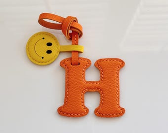 Llavero de cuero personalizado con letra y dije de carita sonriente, adorno para bolso hecho a mano.