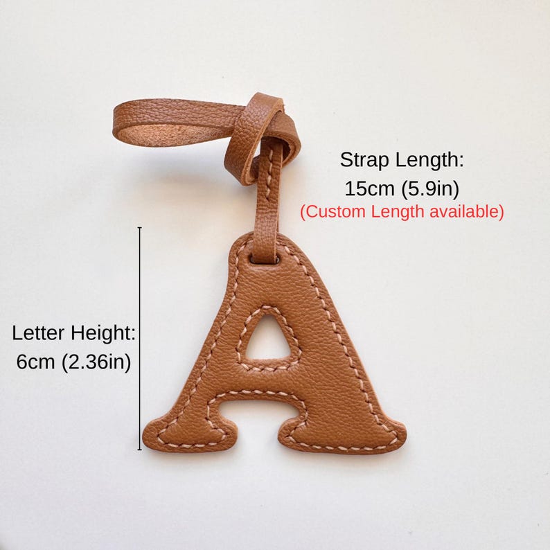 May include: A brown leather luggage tag in the shape of the letter "A" with a strap. The letter height is 2.36 inches, and the strap length is 5.9 inches. The tag has a stitched border.