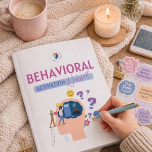 May include: A white workbook titled "Behavioral Activation Worksheet" with colorful illustrations and text. A lit candle, a pink mug, and stickers with motivational phrases are also visible. A blue pen is held near the workbook.