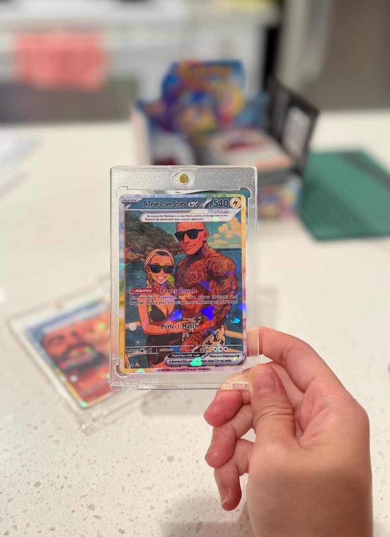 May include: A custom trading card in a clear magnetic protective case featuring an illustration of a couple wearing sunglasses on a beach. The card displays the text A True Love Story ex, 540 HP, Ability Power Couple, and Perfect Match with holographic details.