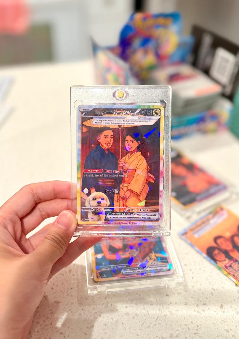 May include: A custom trading card in a clear magnetic protective case featuring an illustration of two people in traditional Japanese clothing holding an umbrella with a small white dog. The card text includes Happy Anniversary ex, Ability One and Only, and Pet Ellie.