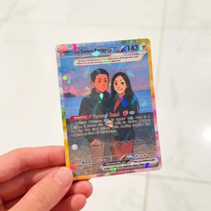 May include: A rectangular trading card featuring a holographic finish and an illustration of two people standing on a beach at sunset. The text reads The Forever Partner EX, 143 HP, Ability Forever Bond, and I choose you now and always.