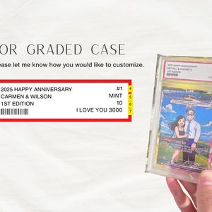 May include: A custom graded card case featuring a personalized label with the text 2025 HAPPY ANNIVERSARY, CARMEN & WILSON, 1ST EDITION, MINT 10, and I LOVE YOU 3000. The card inside displays an illustration of two people standing in a landscape.