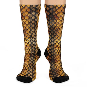 May include: A pair of black and gold socks with a snake skin pattern.