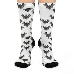 May include: White socks with a black bat pattern. The socks are crew length and have a black cuff.