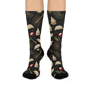 May include: A pair of black socks with a repeating pattern of dumplings, chopsticks, and red cherries on a black background.
