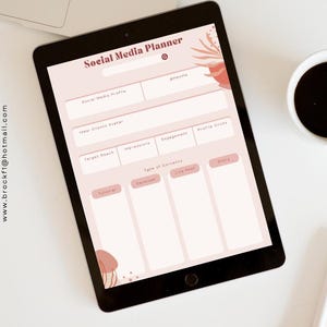 Może przedstawiać: Czarny tablet wyświetla różowo-biały plan społecznościowy. Plan zawiera sekcje dla profili społecznościowych i typów treści. Obok tabletu na białej powierzchni znajduje się filiżanka kawy i długopis.