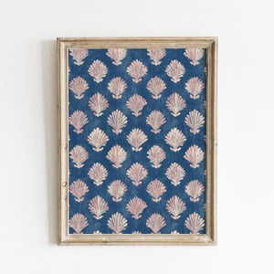 May include: Framed print featuring a repeating pattern of stylized, light pink seashells on a dark blue background. The seashells have a textured appearance. The frame is a light, neutral color.