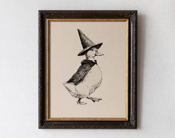 May include: A framed wall art print featuring a black ink sketch of a duck wearing a pointed wizard hat and a cape. The drawing is centered on a light beige background and enclosed in a dark brown ornate frame with a thin gold inner border.