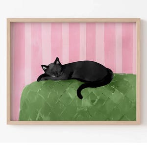 Könnte beinhalten: Gerahmter Kunstdruck mit einer schwarzen Katze, die auf einem grünen Kissen schläft. Der Hintergrund hat rosa und weiße vertikale Streifen. Die Katze ist in einem minimalistischen Stil gemalt.