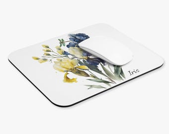May include: A white mouse mat with a watercolour illustration of blue and yellow iris flowers. The text "Iris" is printed in black at the bottom right corner of the mouse mat.