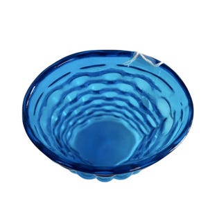K&ouml;nnte beinhalten: Eine blaue Glassch&uuml;ssel mit einem strukturierten, gewellten Design. Die Sch&uuml;ssel ist leer und hat eine abgerundete Form.