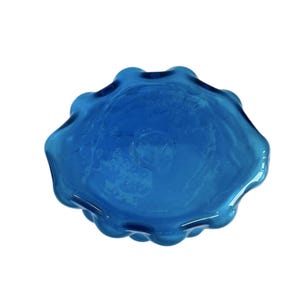 K&ouml;nnte beinhalten: Eine blaue Glassch&uuml;ssel mit einem wellenf&ouml;rmigen, unregelm&auml;&szlig;igen Rand. Die Sch&uuml;ssel ist aus dickem Glas und hat eine leicht tr&uuml;be Optik.