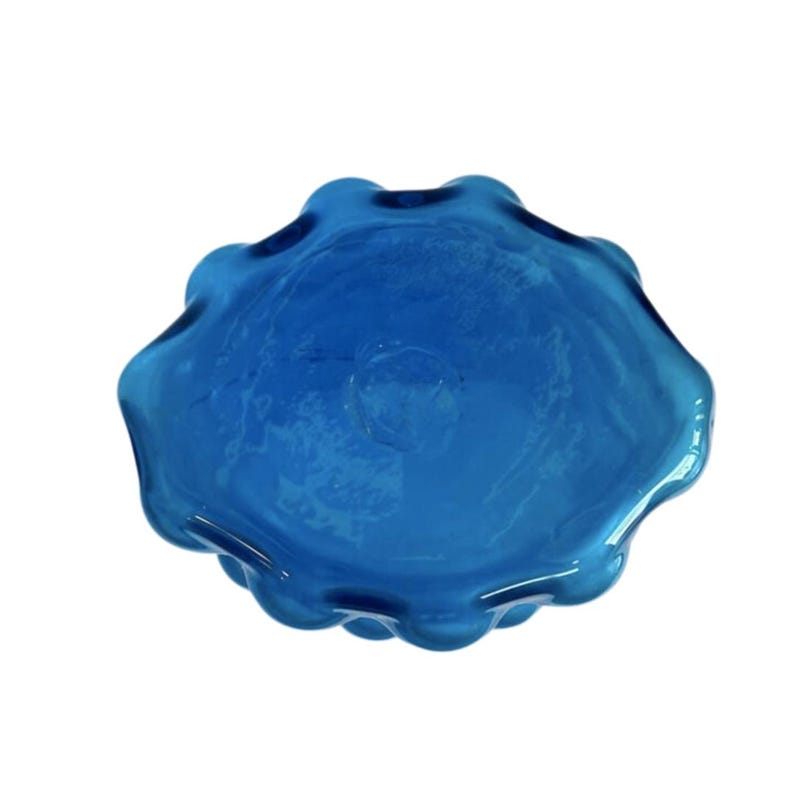 K&ouml;nnte beinhalten: Eine blaue Glassch&uuml;ssel mit einem wellenf&ouml;rmigen, unregelm&auml;&szlig;igen Rand. Die Sch&uuml;ssel ist aus dickem Glas und hat eine leicht tr&uuml;be Optik.