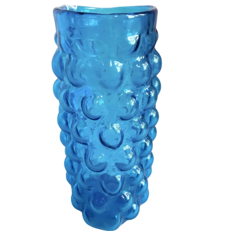 K&ouml;nnte beinhalten: Eine hohe, blaue Glasvase mit einem strukturierten, blasenartigen Design. Die Vase ist aus klarem Glas und hat eine abgerundete, zylindrische Form.