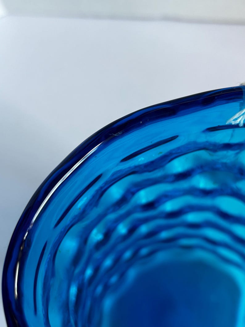 K&ouml;nnte beinhalten: Nahaufnahme des Inneren einer blauen Glassch&uuml;ssel mit einem wellenf&ouml;rmigen, strukturierten Design.