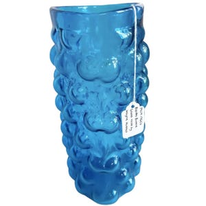 K&ouml;nnte beinhalten: Eine blaue Glasvase mit einer Blasenstruktur. Die Vase ist mit "Finn 1960s, Bizzaro Buvne, Glasvase von Wayne Hummel." beschriftet.
