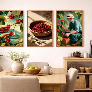 Puede incluir: Conjunto de tres grabados artísticos enmarcados que representan la cosecha de café. Uno muestra cerezas de café rojas en una rama, otro una cesta de cerezas y el tercero una persona recogiendo cerezas. El arte tiene una paleta de colores cálidos.