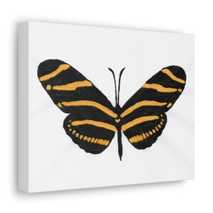 Puede incluir: Una mariposa negra y dorada con alas rayadas sobre un fondo blanco.