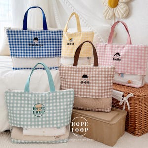 May include: Five rectangular tote bags with gingham patterns in blue, yellow, pink, brown, and light green. Each bag features a clear bottom section, fabric handles, and embroidered character designs with text including Mango, Molly, and Hope Loop.