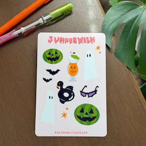 May include: A rectangular sticker sheet featuring the text SUMMERWEEN at the top and GLOOMYLITTLEPOSY at the bottom. The sheet includes illustrations of two green watermelon jack-o'-lanterns, two white ghosts, a tropical drink, two bats, a black swan float, sunglasses, and orange stars.