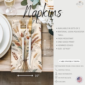 May include: Cream-colored napkin with a wheat and floral design, measuring 10 inches by 10 inches. The napkin is made of 100% polyester twill and features a one-sided print with hemmed edges. A gold fork and knife are placed on top.