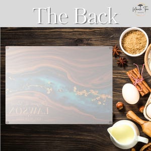May include: A rectangular cutting board with a marbled design in shades of brown, blue, and gold. The text "The Back" is at the top. The board is surrounded by baking ingredients on a wooden surface.