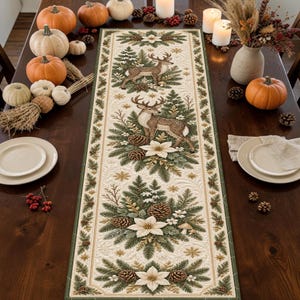 May include: A rectangular table runner featuring a cream-colored fabric with a repeating pattern of brown deer, green pine branches, pinecones, and white poinsettia flowers. The runner has a dark green border and intricate quilted stitching details.