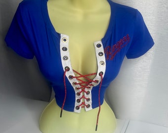 May include: A royal blue crop top with a white lace-up front and red glitter lettering that says "Roxy".