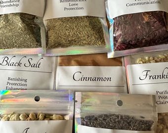 May include: Assortment of sealed pouches containing various herbs and spices, including mint, rosemary, poppy, black salt, cinnamon, jasmine, and lavender. Each pouch is labeled with the herb's name and associated properties.