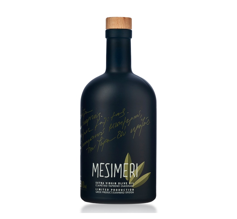 Op de afbeelding: Een zwarte glazen fles Mesimeri Extra Vierge Olijfolie met een kurken dop. De fles heeft een groen etiket met de tekst "Mesimeri Extra Vierge Olijfolie" en "Limited Production".