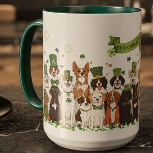 May include: White ceramic mug with a green rim and handle. The mug features a design of dogs wearing green hats and shamrocks with the text "St. Patrick's Day" on the side.