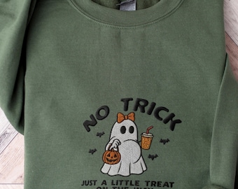 May include: An olive green crewneck sweatshirt featuring an embroidered design of a white ghost wearing an orange bow, holding a jack-o'-lantern bucket and a coffee cup. The text reads NO TRICK JUST A LITTLE TREAT ON THE WAY with small bats.