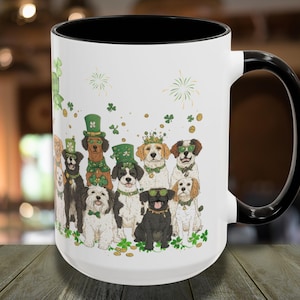 May include: White ceramic coffee mug with a black handle. The mug features a colorful illustration of dogs wearing shamrock hats and green clothing. The dogs are surrounded by shamrocks and gold coins.
