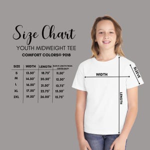 May include: A size chart for a Comfort Colors 9018 youth midweight tee. The chart lists sizes S through 2XL with corresponding width, length, and sleeve length measurements in inches. A white t-shirt is shown with arrows indicating measurement points.