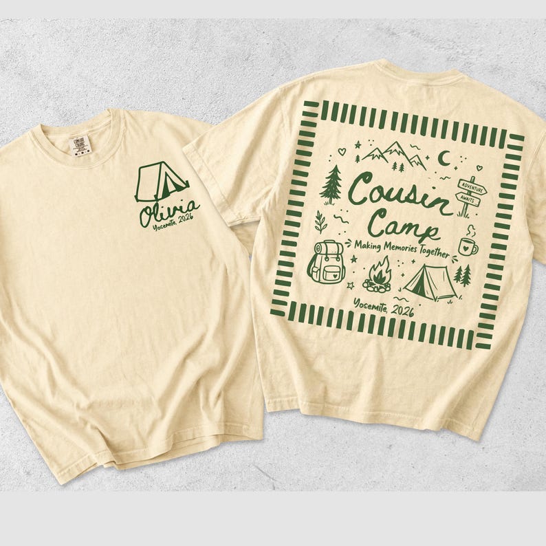 May include: A cream-coloured t-shirt featuring dark green graphics. The front displays a tent icon with the text Olivia Yosemite 2026. The back features a square border enclosing the text Cousin Camp Making Memories Together Yosemite 2026, surrounded by illustrations of mountains, a backpack, a campfire, a tent, and a signpost.