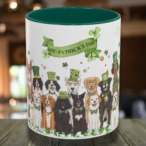May include: White ceramic mug with a green rim, featuring a festive St. Patrick's Day design. The mug depicts a group of dogs wearing shamrock hats and holding green shamrocks. The text "St. Patrick's Day" is displayed on a green banner.
