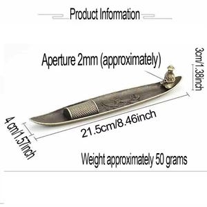 May include: A bronze-colored metal incense holder shaped like a boat, measuring 8.46 inches long, 1.57 inches wide, and 1.38 inches high. It features a small figure at one end, a textured cylindrical holder, and an aperture of 0.08 inches.