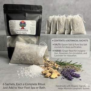 May include: A black pouch labeled Lymphosoak Foot Salts containing six white botanical sachets. The contents include Epsom salt, sea salt, ginger root, rosemary, and lavender. Text on the packaging details the ingredients and usage instructions.