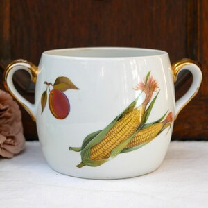 May include: White porcelain soup tureen with gold trim and a hand-painted design of corn on the cob and a plum.