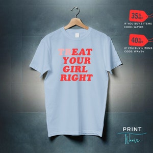 May include: Light blue t-shirt with the text "TREAT YOUR GIRL RIGHT" in red and pink lettering. The text is in a bold, retro font.