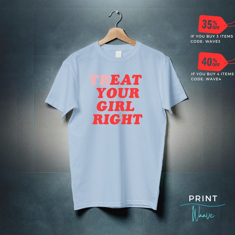 May include: Light blue t-shirt with the text "TREAT YOUR GIRL RIGHT" in red and pink lettering. The text is in a bold, retro font.
