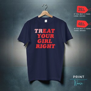 May include: Navy blue t-shirt with the text "TREAT YOUR GIRL RIGHT" in red and pink lettering. The text is in a retro font style.