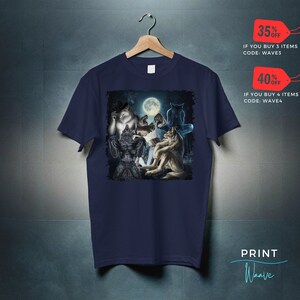 May include: Navy blue t-shirt featuring a graphic of several werewolves under a full moon. The design includes various werewolf figures in different poses. The shirt is hanging on a wooden hanger.