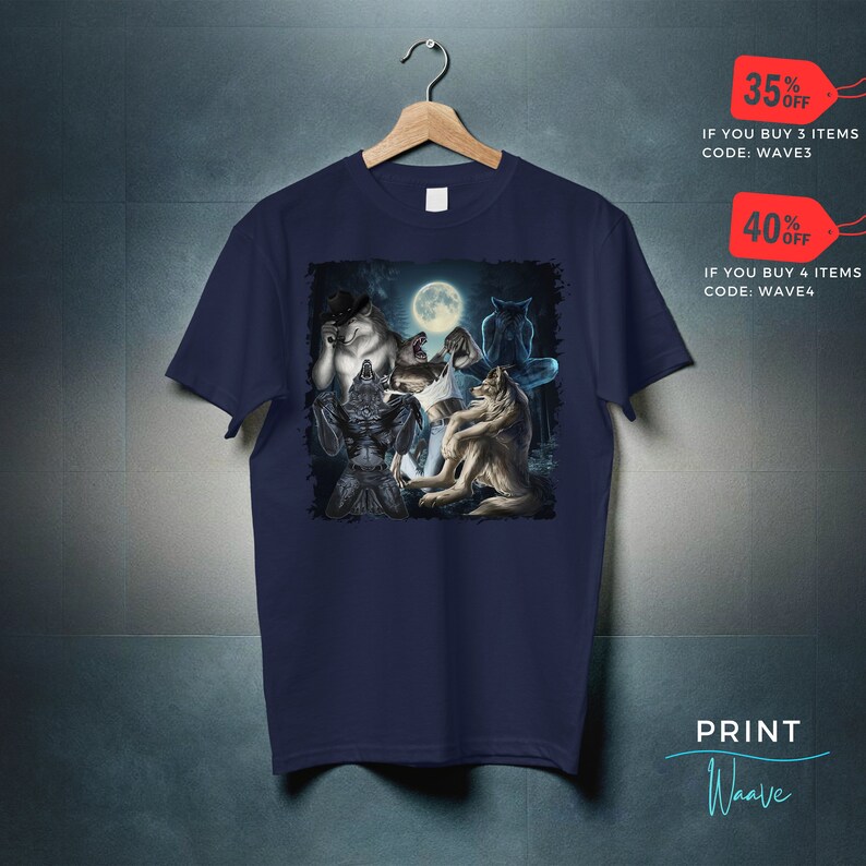 May include: Navy blue t-shirt featuring a graphic of several werewolves under a full moon. The design includes various werewolf figures in different poses. The shirt is hanging on a wooden hanger.