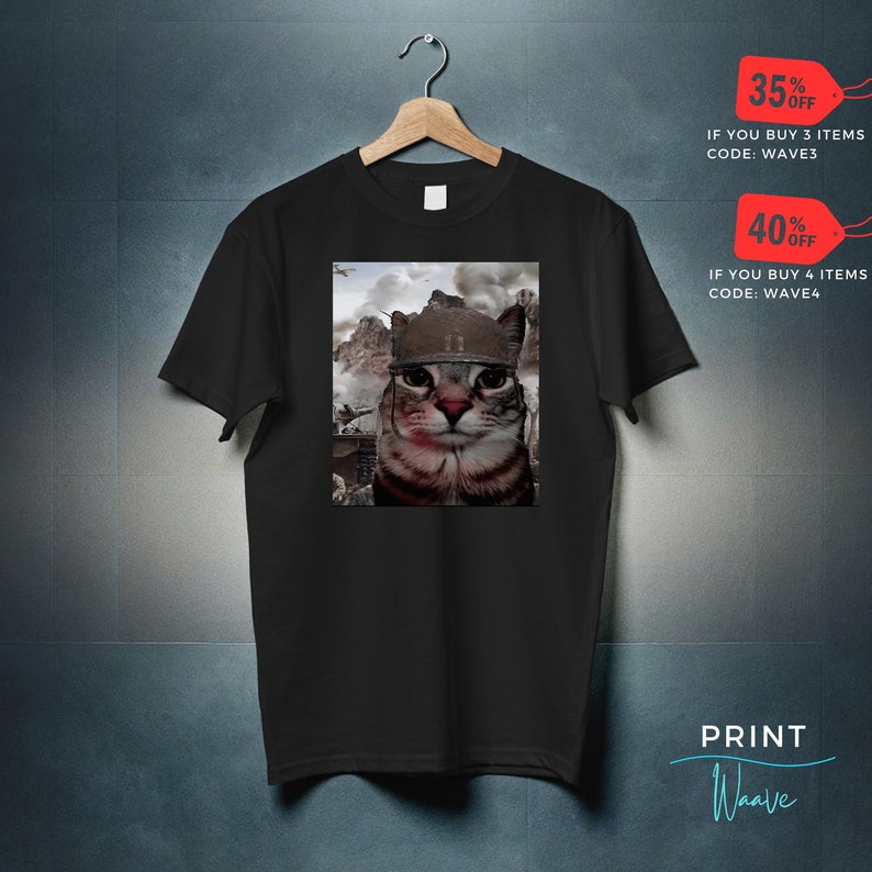 May include: Black t-shirt with a graphic of a cat wearing a military helmet. The cat is looking directly at the viewer. The background is a blurry image of a war scene. The text "35% OFF IF YOU BUY 3 ITEMS CODE: WAVE3" and "40% OFF IF YOU BUY 4 ITEMS CODE: WAVE4" is printed on the image. The text "PRINT Waave" is printed on the bottom right corner of the image.