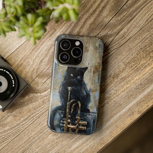 May include: A black cat sits on a gold trumpet with a painted background. The phone case is designed for an iPhone.